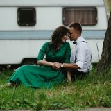 man and woman relaxing on the grass under a tree
